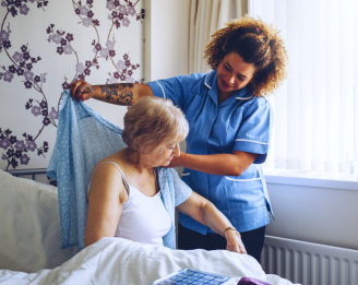 caregiver dressing her patient