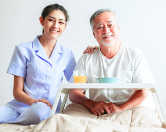 smiling caregiver serving food to her patient